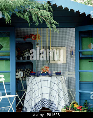 Blau + weißes Tuch auf den Tisch vor der blaue Sommerhaus in Land Garten im Sommer Stockfoto