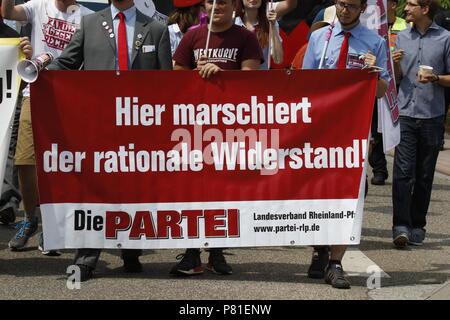 Kandel, Deutschland. 07 Juli, 2018. Gegen Demonstranten aus der Partei 'Die Partei' ein Banner mit der Aufschrift "Hier marschiert die rationelle Widerstand', ein Wort, das Spiel auf "Nationaler Widerstand", der Name einer Gruppe von rechtsextremen Organisationen in Deutschland. Rund 200 Menschen von Rechten Organisationen protestierten für das 10. mal in der Stadt Kandel in der Pfalz gegen Flüchtlinge, Ausländer und der deutschen Regierung. Sie forderten mehr Sicherheit von Deutschen und Frauen aus der angeblichen Zunahme der Gewalt durch Flüchtlinge. An die Stelle der Protest war wegen der 2017 Kandel erstechen Angriff, in dem ausgewählt Stockfoto