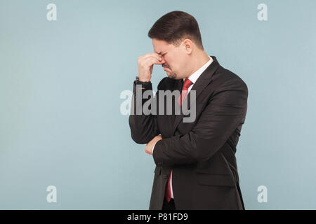 Looser Geschäftsmann, schreien, und Hoffnung. Einen neuen Job und viele Geld benötigen. indoor Studio erschossen. auf hellblauem Hintergrund isoliert. gut aussehender Geschäftsmann mit Stockfoto