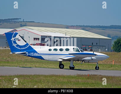 Eine Cessna 402 B Twin Privatflugzeuge D-Isav in Inverness Dalcross Flughafen in den schottischen Highlands anreisen. Stockfoto