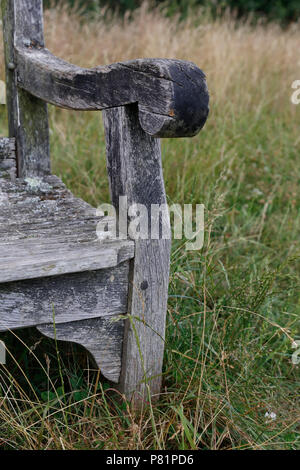 Detail der alten Holzbank im Gras Stockfoto