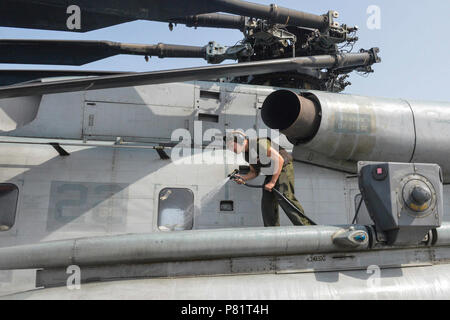 Golf von Aden (Aug. 20, 2016) Marine Cpl. Johnathan Mecklin wäscht Ein CH-53E Super Stallion Hubschrauber auf dem Flugdeck des amphibious Transport dock Schiff USS San Antonio (LPD 17). San Antonio ist als Teil der Wasp Amphibious Ready Gruppe implementiert Maritime Security Operations und Theater Sicherheit Zusammenarbeit in USA 5 Flotte Bereich der Operationen durchzuführen. Stockfoto