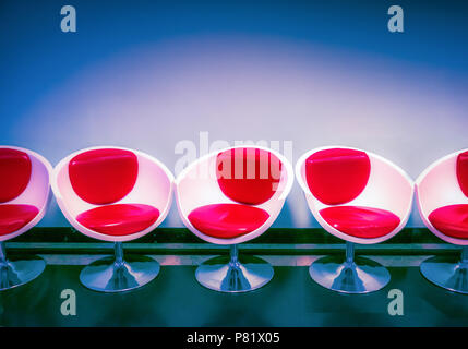 Reihe von roten und weißen Retro-Schaumsesseln, futuristische Loungemöbel, kühnes minimalistisches Designkonzept Stockfoto