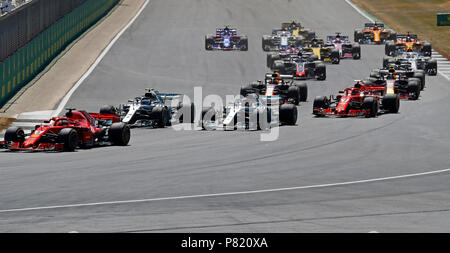 Ferrari's Sebastian Vettel führt in der ersten Kurve von Mercedes' Valtteri Bottas und Lewis Hamilton im Grand Prix von Großbritannien 2018 in Silverstone Circuit, Towcester gefolgt. Stockfoto