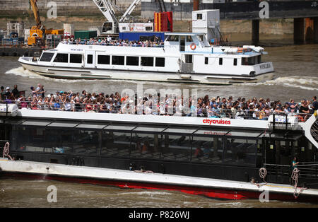 Passagiere auf eine Bootsfahrt entlang der Themse, London, als das warme Wetter weiterhin über dem Land. Stockfoto