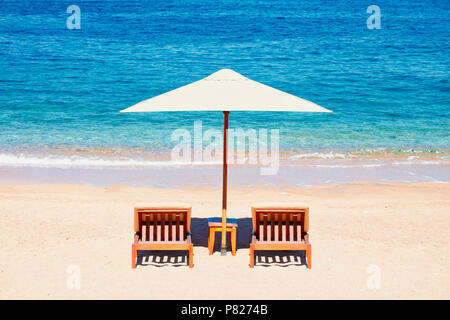 Sommerferien Hintergrundbild: zwei Liegestühle unter Zelt am Strand. Stockfoto