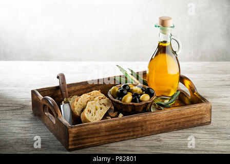 Olivenöl mit Brot, Oliven auf einen hölzernen Tisch. Konzept der Natur und gesunde Ernährung Stockfoto