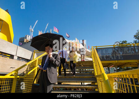 Japanische Touristen auf dem Londoner Southbank schützen sich vor der Sonne mit Sonnenschirmen Stockfoto