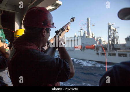 Roten Meer (1. April 2016) Die Gunner Mate 3. Klasse Johnathan Sanchez, von las Cruzes, New Mexico, feuert eine shotline von Bord der Amphibisches Schiff USS Kearsarge (LHD 3) Während eine Auffüll-anforderung auf See mit der Royal Fleet Auxiliary (RFA) Schiff Fort Victoria (A 387). Kearsarge ist das Flaggschiff der Kearsarge Amphibious Ready Group (ARG) und, mit dem begonnen 26 Marine Expeditionary Unit (MEU), ist zur Unterstützung der Maritime Security Operations und Theater Sicherheit Zusammenarbeit in den USA 5 Flotte Bereich der Operationen eingesetzt. Stockfoto