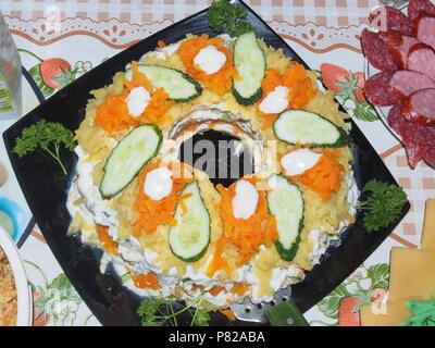 Salat auf einen Teller geben und mit Kräutern und Gurken eingerichtet. Still-Leben Stockfoto