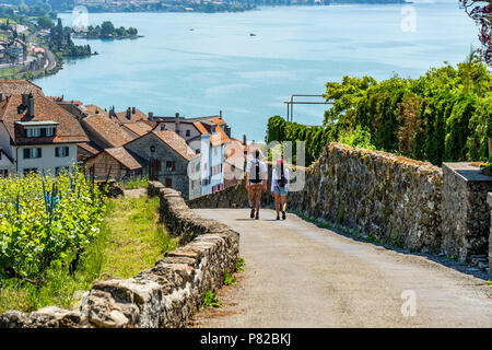 Zwei jungen Touristen wandern in Richtung des Dorfes Rivaz, Schweiz Stockfoto