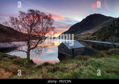 Die boathouse auf LLyn Ogwen bei Sonnenaufgang mit Tryfan in der Ferne erfasst. Stockfoto