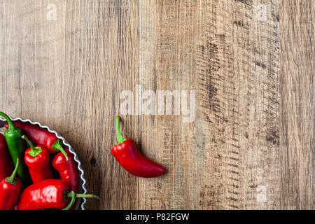 Rote und grüne Chili Pfeffer in einer Schüssel auf hölzernen Tisch mit Platz kopieren Stockfoto
