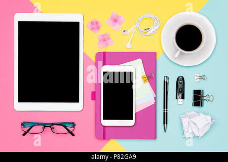 Büro Schreibtisch Arbeitsfläche Flach. Ansicht von oben Foto von Arbeitsbereich mit leeren Mock up Tablet und Smartphone, Kaffeetasse, Notepad und Gläser. Stockfoto
