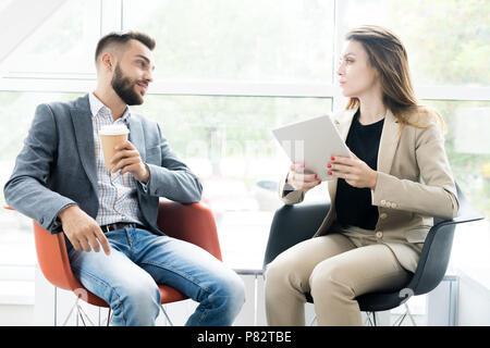 Zwei moderne Geschäftsleute Entspannen in Stühle Stockfoto