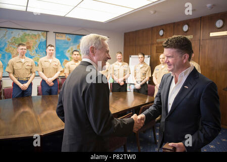 (27. Juni 2016) Der Sekretär der Navy (Secnav) Ray Mabus begrüßt US-Botschafter in Großbritannien, Matthew Barzun bei einem Besuch in der Botschaft. Mabus ist in der Region als Teil einer multinationalen Tour zu den Europäischen Befehl Verantwortungsbereich Matrosen und Marines, und die Regierung und Militärs zu erfüllen. Stockfoto