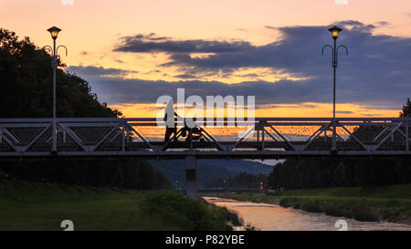 Liebe Brücke in Pirot bei Sonnenuntergang und Silhouetten von ein paar mit Kinderwagen Stockfoto