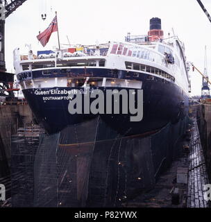 AJAXNETPHOTO. Dez 1996. SOUTHAMPTON, England. - Steuerbord QUARTAL ANGESICHTS DER CUNARD PASSAGIERSCHIFF QUEEN ELIZABETH 2-QE 2-IN KGV-DRY DOCK, ihrem Rumpf eingehüllt in Netting, erfährt wieder einbauen. Foto: Jonathan Eastland/AJAX. REF: 1296 33 Stockfoto