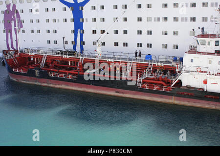 Bereitstellung von Schiff tanken grossen weissen Passagier Kreuzfahrtschiff. Betankung von schweren Nutzfahrzeugen Schiff im Wasser am Hafen. Stockfoto