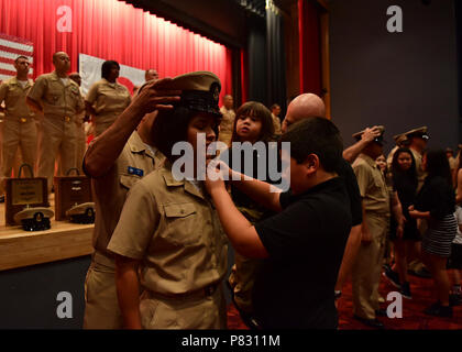 YOKOSUKA, Japan (Sept. 16, 2016) - Chief Legalman Giannina Gutierrez, Commander 7 Flotte Personal angeschlossen, erhält von ihrer Familie Mitglieder und Mentor Chief Marine Ratgeber Jason Caldera während einer pinning Zeremonie an Commander, Flotte Aktivitäten Yokosuka festgesteckt. 14 Befehle, einschließlich den USA 7 Flotte Flaggschiff USS Blue Ridge LCC (19), in einem gemeinsamen - Chief Jahreszeit, mit Pinning 42 neue Chief Petty Officers abgeschlossen teilgenommen. Stockfoto