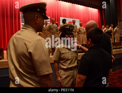 YOKOSUKA, Japan (Sept. 16, 2016) - Chief Legalman Giannina Gutierrez, Commander 7 Flotte Personal angeschlossen, erhält von ihrer Familie Mitglieder und Mentor Chief Marine Ratgeber Jason Caldera während einer pinning Zeremonie an Commander, Flotte Aktivitäten Yokosuka festgesteckt. 14 Befehle, einschließlich den USA 7 Flotte Flaggschiff USS Blue Ridge LCC (19), in einem gemeinsamen - Chief Jahreszeit, mit Pinning 42 neue Chief Petty Officers abgeschlossen teilgenommen. Stockfoto