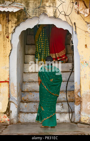 Drei indische Frauen, die eine traditionelle indische Kleidung (Sari) sprechen Miteinander zwischen den Straßen von Jaipur, Rajasthan, Indien. Stockfoto