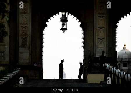 Silhouette von zwei Wachen reden einander vor dem Eingang des Palace Udaipur, Rajasthan, Indien. Stockfoto