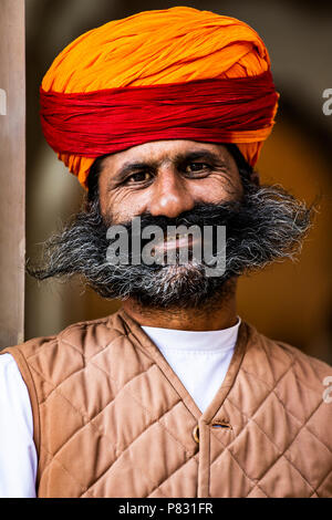 JODHPUR, Rajasthan - Indien - 12. Dezember 2017. Porträt eines lächelnden Rajasthani Mann mit Schnurrbart, Bart und einem rot und orange traditionellen Turban. J Stockfoto