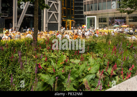 St Helen's Piazza, London. Mitarbeiter im Büro und Touristen verbringen ihre Mittagspause im Sommer Sonnenschein, plaudern, Relaxen, Essen, Trinken Stockfoto