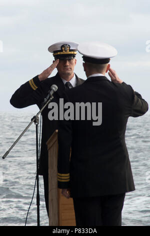 Atlantik (31. 3, 2016) Leutnant Travis Kelley begrüßt Cmdr. Colin Tag, Executive Officer der Flugzeugträger USS George Washington (CVN 73), während einer Bestattung auf See Zeremonie. George Washington, homeported in Norfolk unterwegs ist die Durchführung von Carrier Qualifikationen in den Atlantischen Ozean. Stockfoto