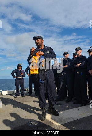 Atlantik (31. 7, 2016) - Petty Officer 2nd class Darcus Morgan leitet Training auf, wie man richtig Don eine aufblasbare Schwimmweste während einer Übung zum Verlassen des Schiffes auf dem Flugdeck der Amphibisches Schiff USS Iwo Jima (LHD7). Iwo Jima ist unterwegs verfolgen Mobility-Engineering (MOB-E) und Mobility-Seaman (MOB-S) Zertifizierungen als Teil des Schiffes vor der Bereitstellung Qualifizierung. Stockfoto
