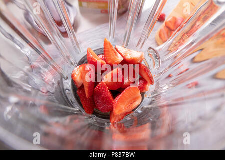 In der Nähe von Glas mixer Shaker mit frischen Reifen Erdbeeren in Scheiben schneiden. Superfoods und Gesundheit oder detox Diät Lebensmittel Konzept. Ansicht von oben Stockfoto