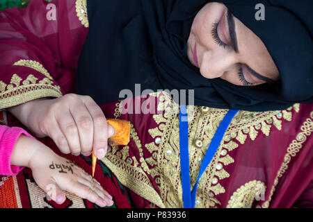 Moskau, Russland. 8. Juli 2018. Eine Frau schreibt Hand eines Kindes das Wort Katar nQatar's World Cup 2022 Pavillon am Puschkinplatz Damm in Gorki Park in Moskau, Russland Credit: Nikolay Winokurow/Alamy leben Nachrichten Stockfoto