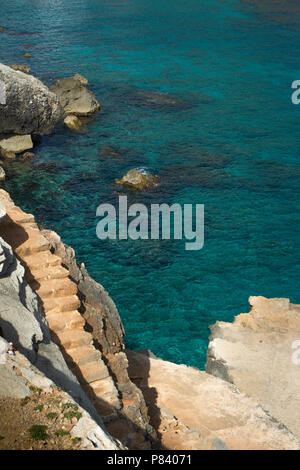 Treppe hin zu klaren türkisfarbenen Wasser des Mittelmeers in Cala Sant Vicenc, Mallorca, Balearen führenden Stockfoto