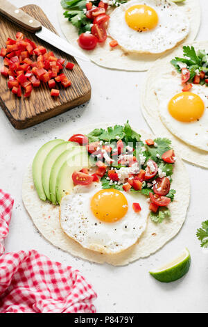 Mexikanische Tortilla mit Salsa, Avocado und Ei auf konkreten Hintergrund, selektive konzentrieren. Schmackhafte Tacos Stockfoto