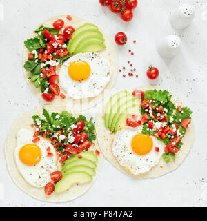 Frühstück tortilla Taco mit Ei, Avocado, Salsa auf hellen Hintergrund, Ansicht von oben, Quadrat Erntegut Stockfoto