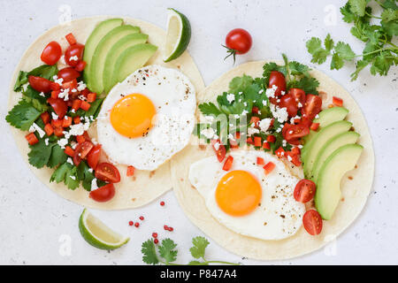 Frühstück tortilla Taco mit Ei, Avocado, Salsa auf hellen Hintergrund, Ansicht von oben Stockfoto