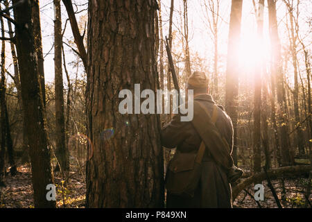 Re-Enactor gekleidet, wie Russische Sowjetische Infanterie Soldat des Zweiten Weltkrieges hält Gewehr Waffe in Händen im Herbst Wald. Stockfoto
