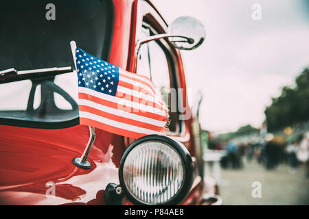 Schließen Seitenansicht des roten Pickup Truck mit einer kleinen amerikanischen Flagge schwenken. Stockfoto