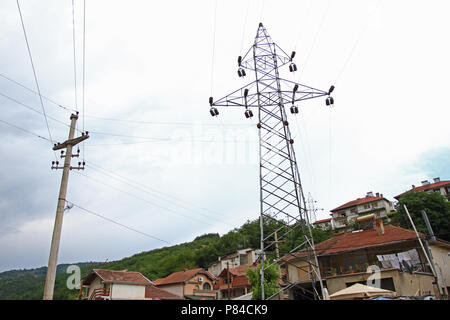 Elektrische Türme mit Kabel für Strom in der Mitte der Stadt. Elektrische Türme zwischen den Häusern. Metall Stangen von Stromleitungen. Hochspannungs-dir Stockfoto