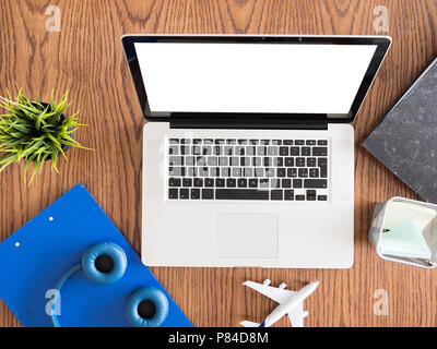 Reisender Geschäftsmann Konzept Bild auf dem Schreibtisch aus Holz, Kopfhörer, Kanne Gras Stockfoto