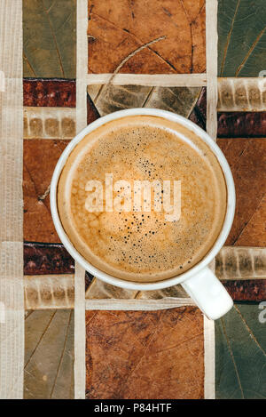 Kaffeebecher von oben auf Blatt Hintergrund Stockfoto