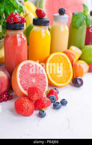 Viele verschiedene Früchte und Beeren und Säfte in Kunststoffflaschen. Wassermelonen, Bananen, applesin, Heidelbeeren, Erdbeeren, Basilikum. Vitamin- und gesundes Essen. Platz kopieren Stockfoto