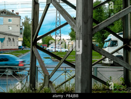 Mast Stromleitungen und Stadt Straße mit vorbeifahrenden Autos. Stockfoto