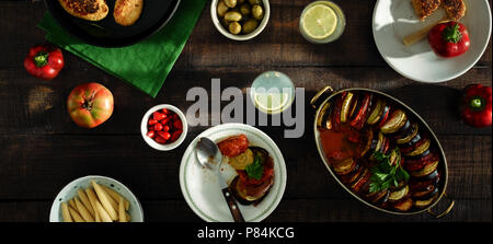 Verschiedene vegetarische Speisen auf Holztisch. Ratatouille, Kichererbsen Koteletts, Limonade und verschiedene Snacks, Ansicht von oben. Vegetarisches Abendessen Tabelle Konzept Stockfoto