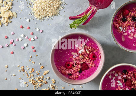 Berry rote Beete frische Smoothies zum Frühstück in Keramik Schalen auf einem grauen Stein Hintergrund mit Rüben. Flach Stockfoto