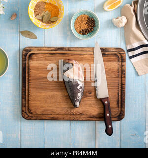 Frischen, rohen Fisch mit Zitrone und Gewürze zum Kochen gesunde Ernährung auf Blau Holztisch. Gesunde Ernährung und Diät Konzept, Ansicht von oben Stockfoto