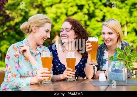 Freunde Toasten mit einem Bier in der Garden Pub Stockfoto