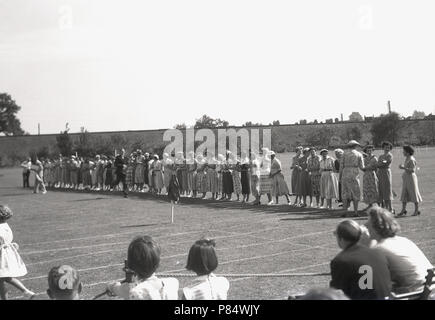 1950er Jahre, Historikall, an den Schulen Sporttag, alle Mütter, alle in Kleidern!, Line-up, um an einem Ei & Löffel Rennen teilnehmen, einer der traditionellen Wettbewerbe ihre Kinder an diesem Tag konkurrieren. Stockfoto