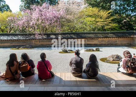 Japanische Touristen genießen Ruhe im Ryoanji-tempel in Kyoto, Japan. Dieser Zen buddhistische Tempel ist berühmt für seine rock garden. Stockfoto